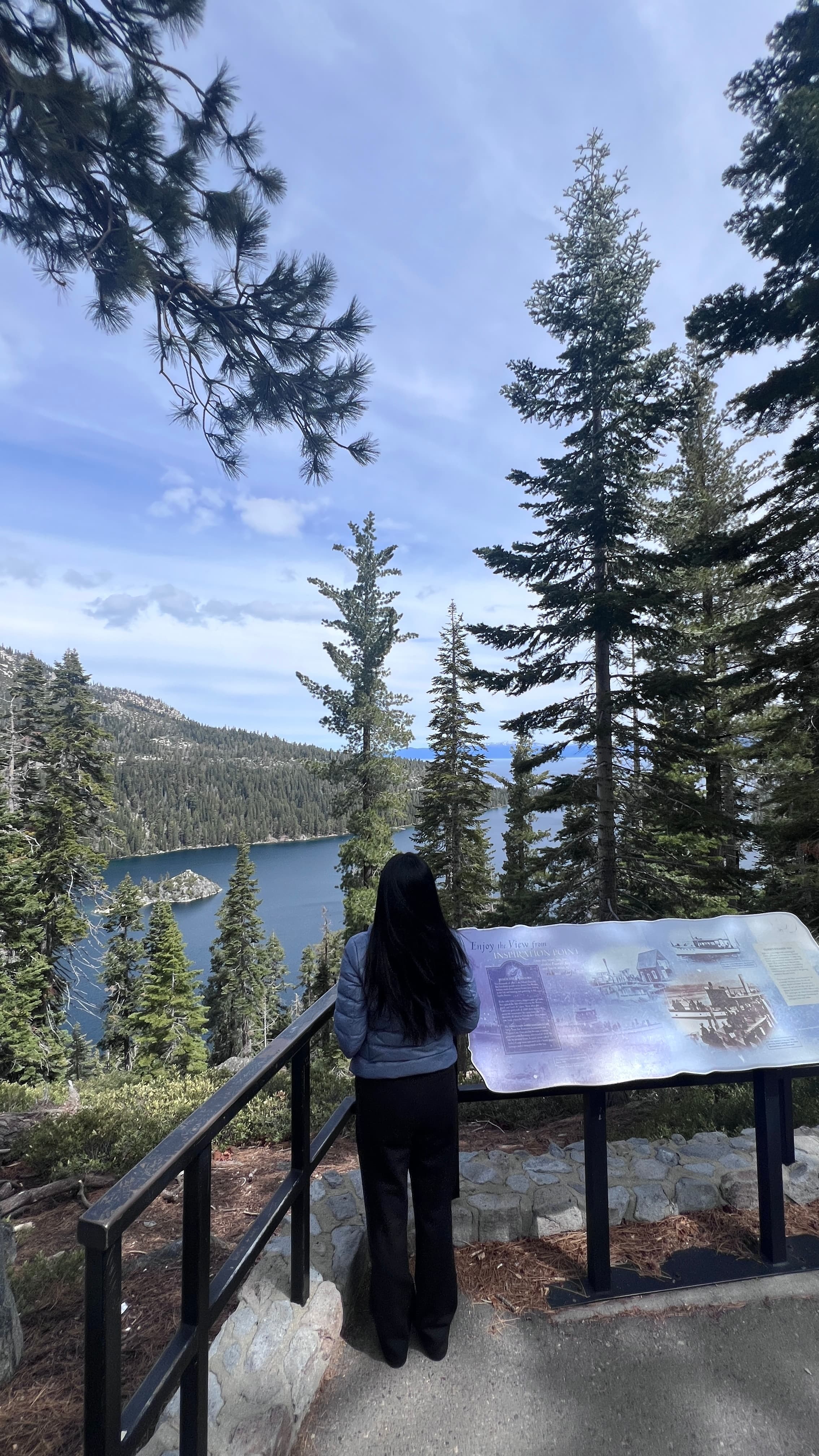 A mountain overlook framed by trees above a blue lake