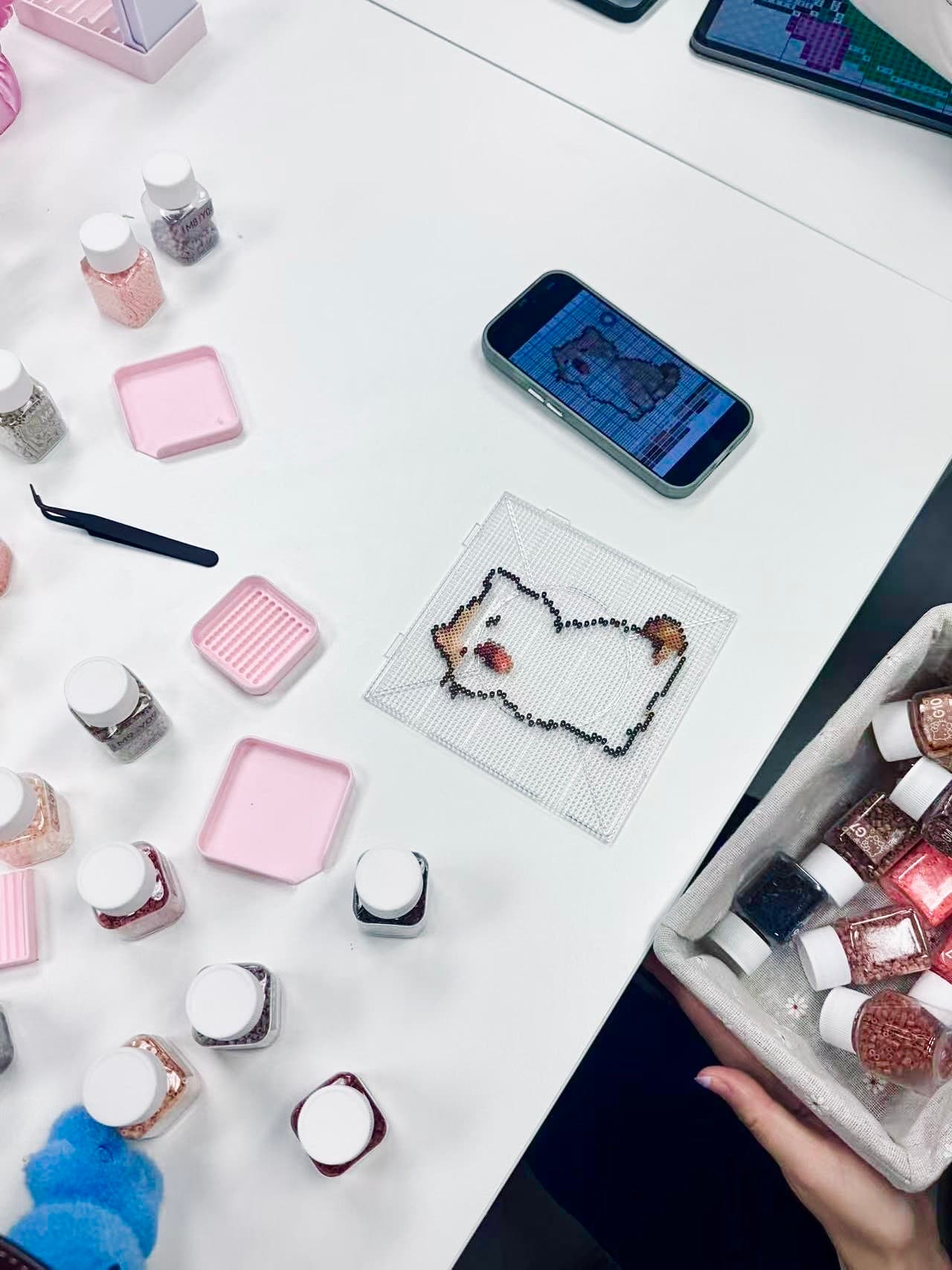 A colorful bead-craft project arranged on a white table